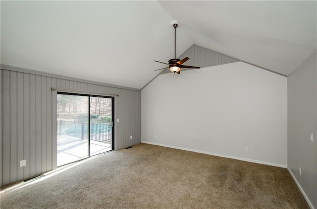 carpeted empty room with lofted ceiling, ceiling fan, and baseboards