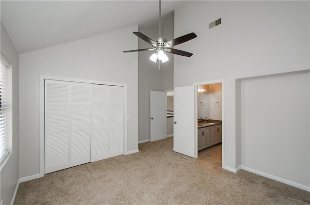 unfurnished bedroom with a closet, visible vents, light carpet, a sink, and baseboards