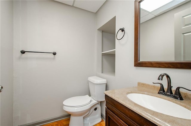 bathroom with toilet, a paneled ceiling, and vanity