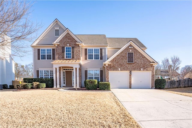 view of front of house with a garage, concrete driveway, brick siding, and fence