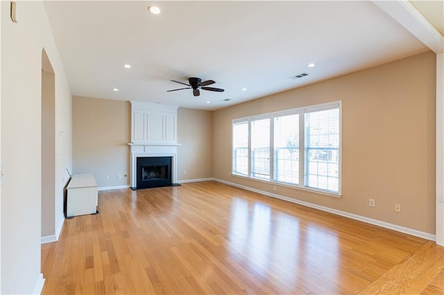 unfurnished living room with recessed lighting, a large fireplace, visible vents, baseboards, and light wood-style floors