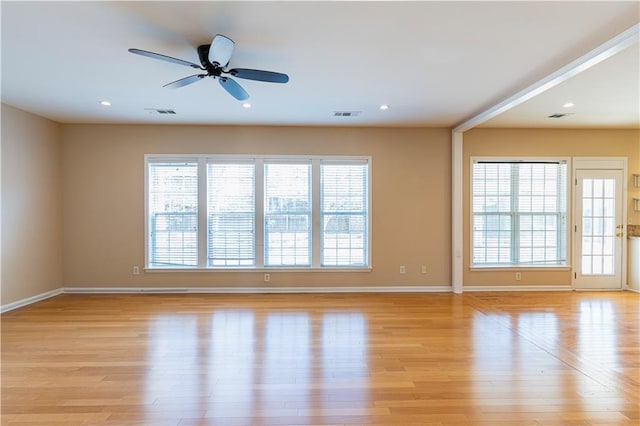 empty room with light wood-type flooring, visible vents, and plenty of natural light