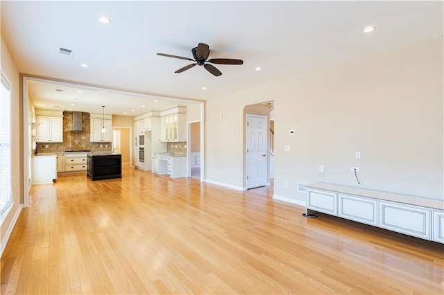 unfurnished living room with visible vents, baseboards, ceiling fan, light wood-type flooring, and recessed lighting