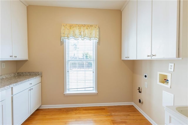 washroom featuring light wood-style flooring, hookup for an electric dryer, washer hookup, baseboards, and cabinet space