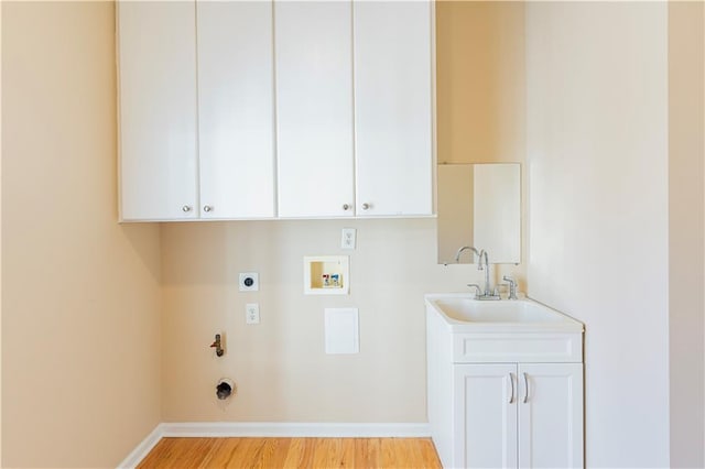 washroom featuring washer hookup, a sink, electric dryer hookup, light wood-type flooring, and baseboards