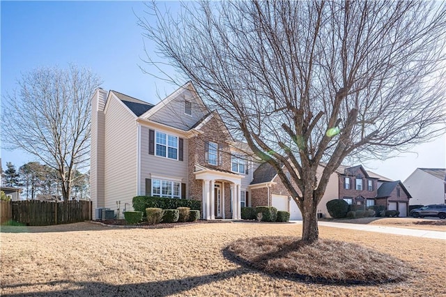 view of front of home with brick siding, a chimney, fence, cooling unit, and driveway