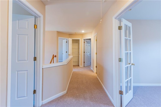 hallway with carpet, french doors, and baseboards