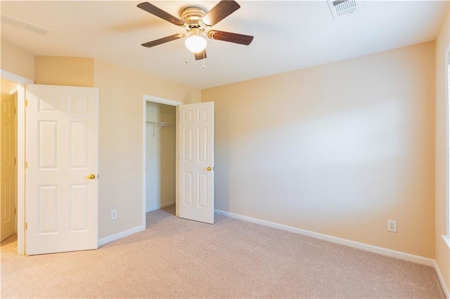 unfurnished bedroom with a closet, light colored carpet, visible vents, and baseboards