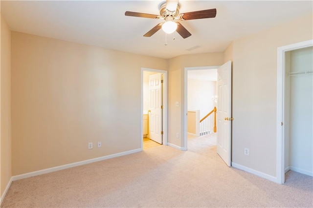 unfurnished bedroom featuring light carpet, visible vents, baseboards, a ceiling fan, and a closet