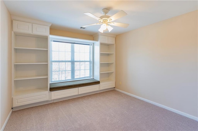 unfurnished room with light carpet, visible vents, baseboards, and a ceiling fan