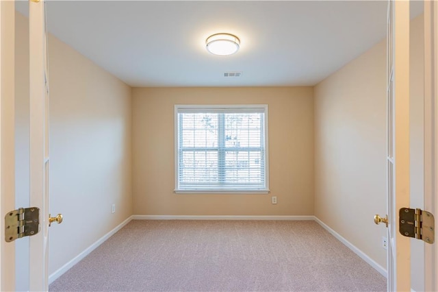 empty room with light colored carpet, visible vents, and baseboards