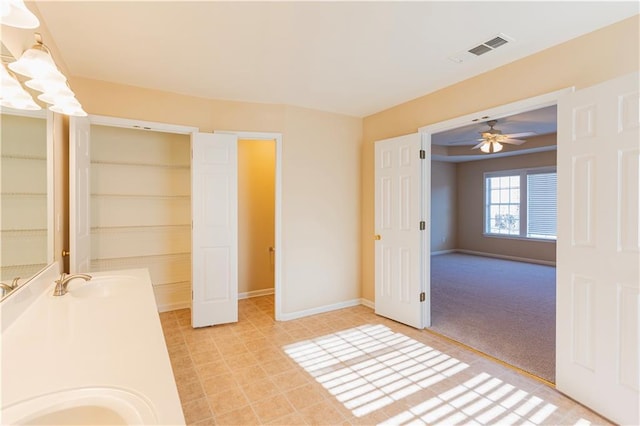 bathroom with double vanity, baseboards, visible vents, and a sink