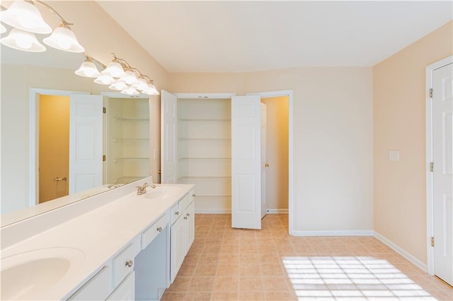 full bath featuring tile patterned floors, a sink, baseboards, and double vanity