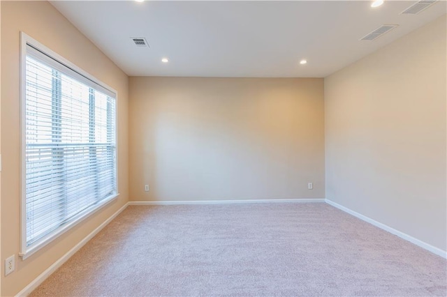 spare room featuring baseboards, visible vents, and recessed lighting