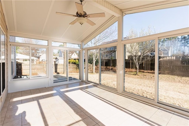 unfurnished sunroom with lofted ceiling with beams, ceiling fan, and plenty of natural light