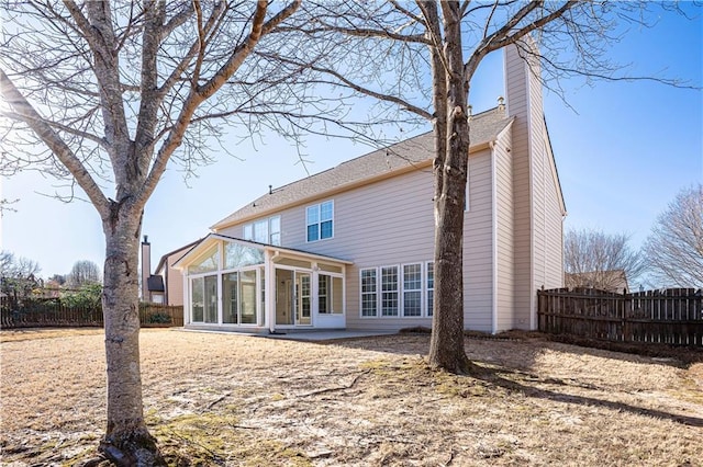 back of property featuring a sunroom, a patio area, fence, and a chimney