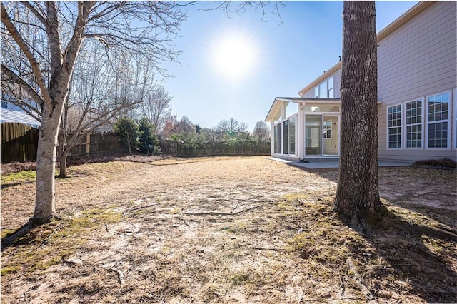 view of yard with a fenced backyard and a sunroom