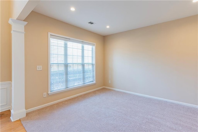 unfurnished room with recessed lighting, ornate columns, light colored carpet, visible vents, and baseboards