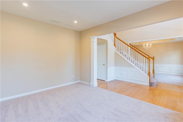 spare room featuring carpet floors, decorative columns, recessed lighting, visible vents, and stairs