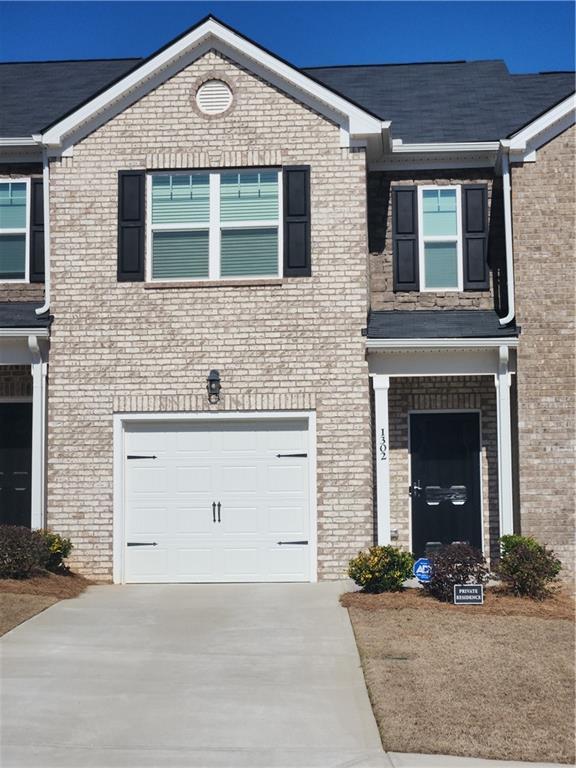 1302 Speckle Park Way, Stockbridge, GA 30281 - view of front facade with brick siding, concrete driveway, and a garage