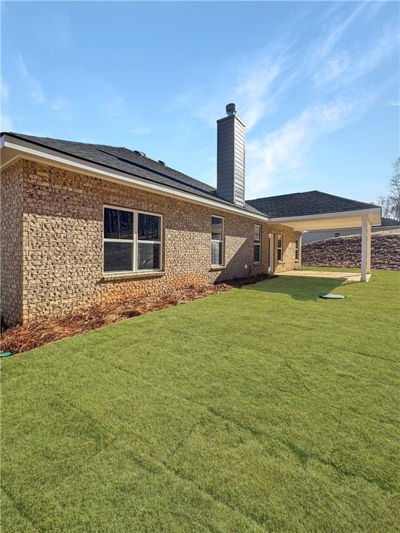 rear view of house featuring a yard