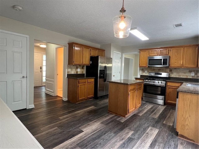 11800 Carriage Park Ln, Johns Creek, GA 30097 - kitchen with appliances with stainless steel finishes, dark countertops, dark wood-style floors, tasteful backsplash, and a textured ceiling