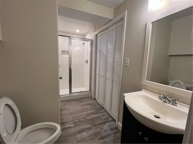11800 Carriage Park Ln, Johns Creek, GA 30097 - bathroom with a closet, a stall shower, vanity, wood finished floors, and recessed lighting