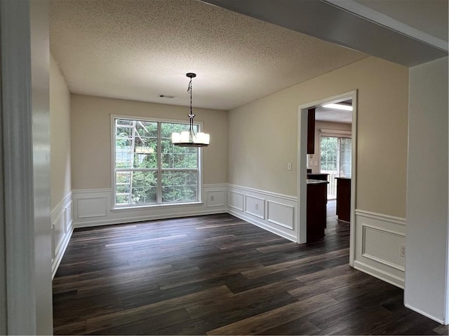 11800 Carriage Park Ln, Johns Creek, GA 30097 - unfurnished dining area with a chandelier, healthy amount of natural light, a decorative wall, a wainscoted wall, and dark wood-style flooring