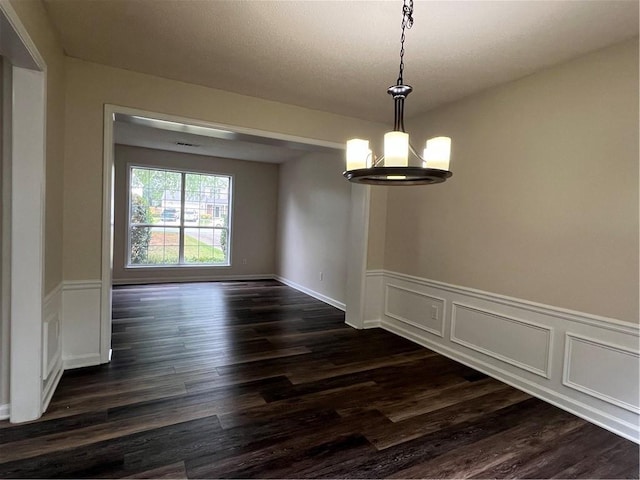 11800 Carriage Park Ln, Johns Creek, GA 30097 - unfurnished dining area featuring dark wood finished floors, a chandelier, a wainscoted wall, and a decorative wall