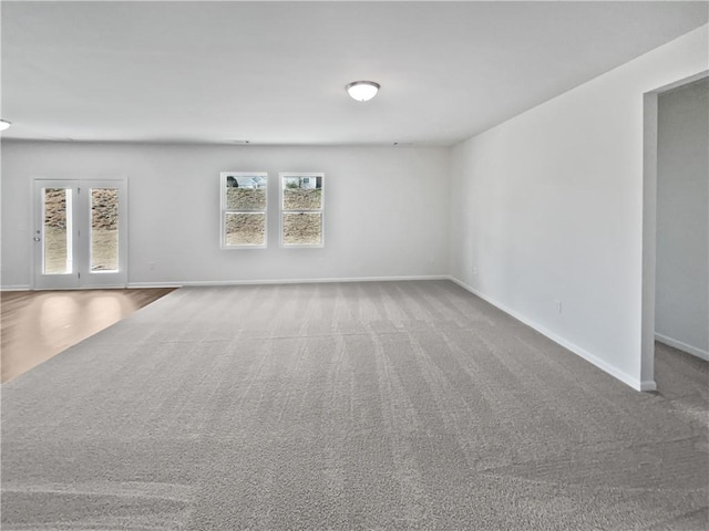 unfurnished living room featuring carpet flooring and baseboards