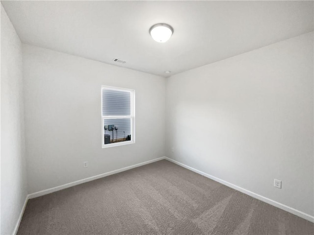 spare room with baseboards, visible vents, and carpet flooring