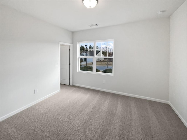 carpeted empty room featuring visible vents and baseboards