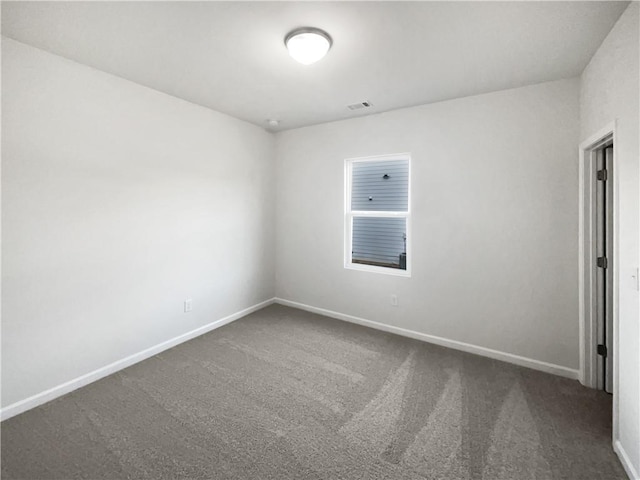 carpeted spare room featuring visible vents and baseboards