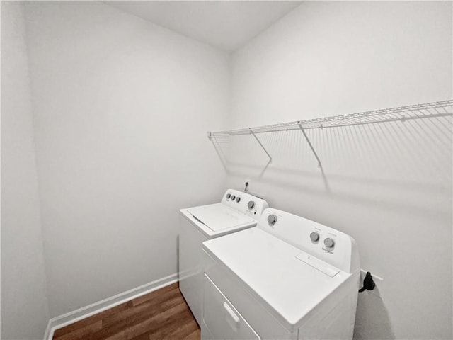 laundry room featuring laundry area, baseboards, dark wood finished floors, and washing machine and clothes dryer