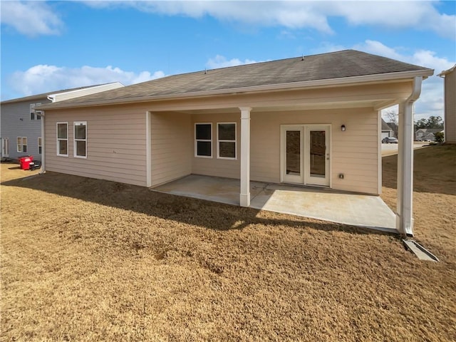 back of property featuring a patio and roof with shingles