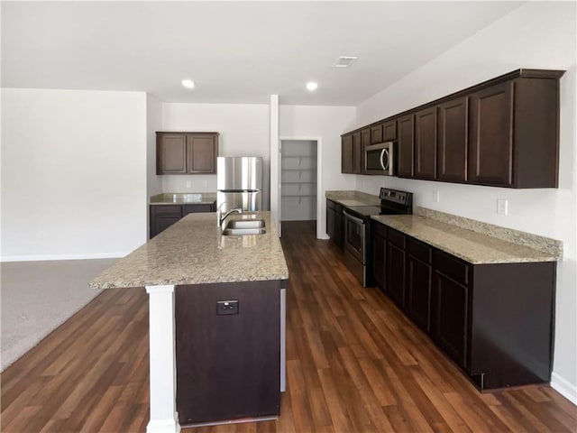 kitchen featuring dark wood-style floors, dark brown cabinets, stainless steel appliances, and a sink