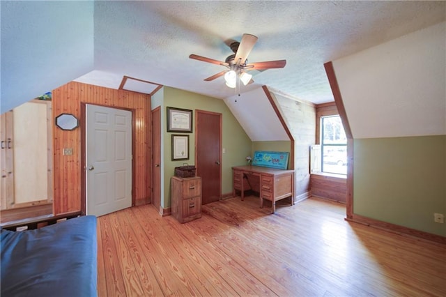 1066 Sea Oats Way SW, Lilburn, GA 30047 - bonus room featuring lofted ceiling, wooden walls, light wood-style floors, a ceiling fan, and a textured ceiling