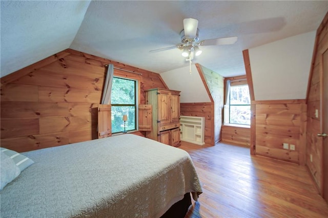 1066 Sea Oats Way SW, Lilburn, GA 30047 - bedroom with wooden walls, vaulted ceiling, light wood-style floors, a textured ceiling, and a ceiling fan