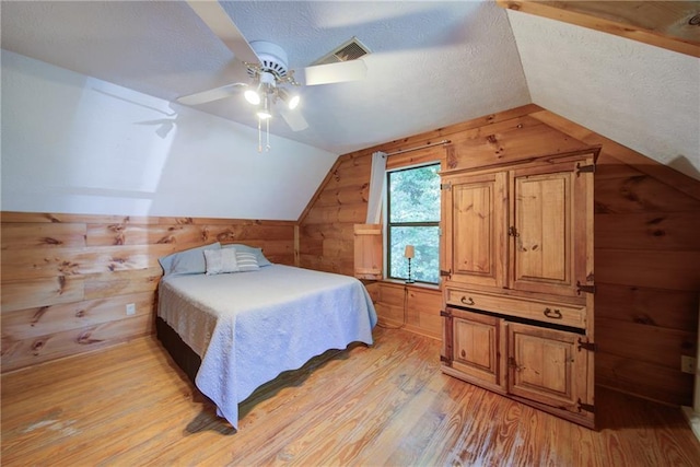 1066 Sea Oats Way SW, Lilburn, GA 30047 - bedroom with wood walls, vaulted ceiling, light wood-type flooring, a textured ceiling, and ceiling fan