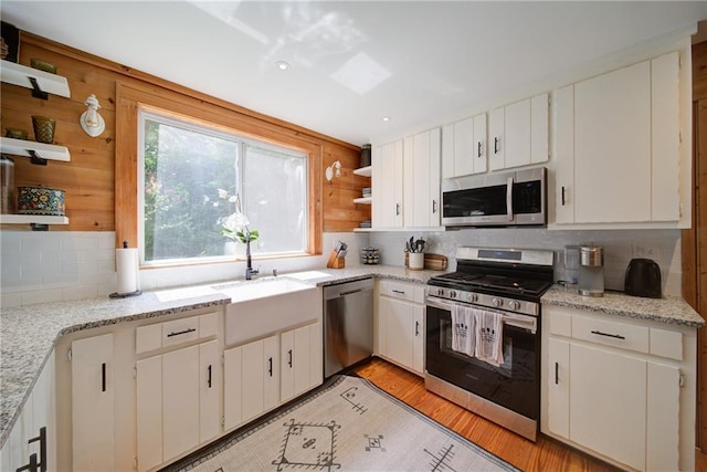 1066 Sea Oats Way SW, Lilburn, GA 30047 - kitchen featuring open shelves, stainless steel appliances, backsplash, white cabinets, and light wood finished floors