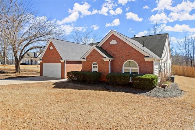 view of front of property with brick siding, fence, and driveway