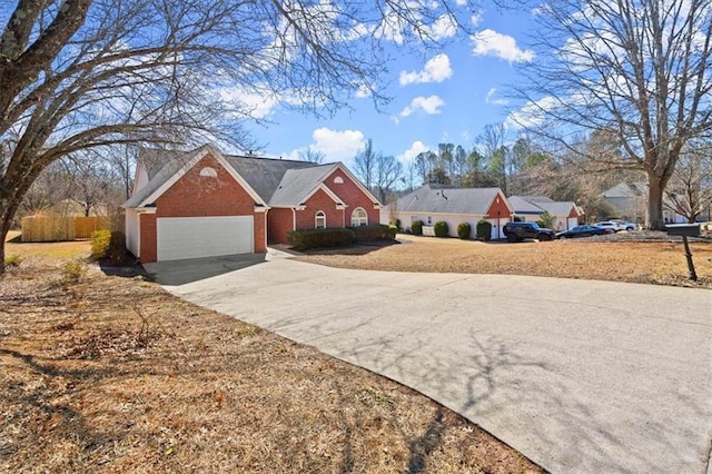 view of front facade featuring driveway, a garage, fence, and brick siding