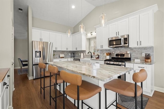 kitchen with appliances with stainless steel finishes, white cabinets, and a center island