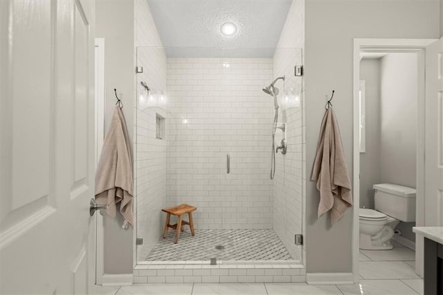 full bathroom featuring a textured ceiling, toilet, vanity, baseboards, and a stall shower