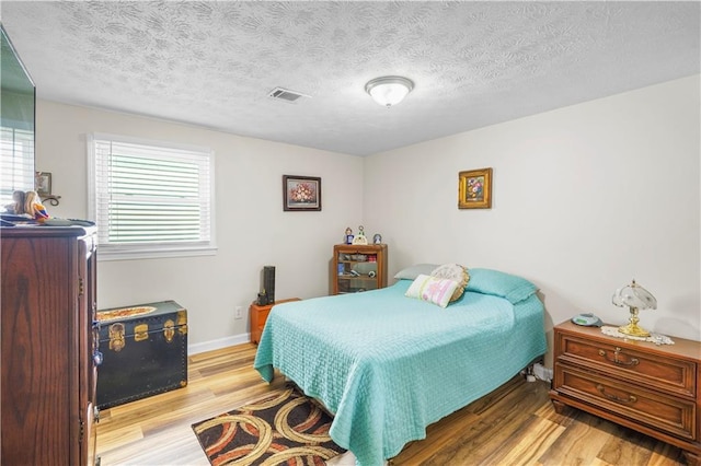 3184 Newcastle Way, Snellville, GA 30039 - bedroom with wood finished floors, a textured ceiling, and baseboards