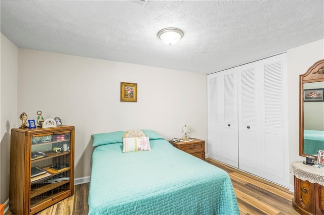 3184 Newcastle Way, Snellville, GA 30039 - bedroom featuring wood finished floors, a closet, and a textured ceiling