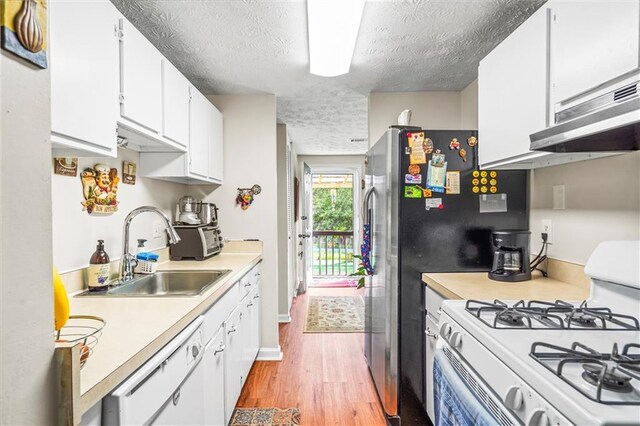 3184 Newcastle Way, Snellville, GA 30039 - kitchen with white appliances, a sink, a textured ceiling, light countertops, and light wood-style flooring