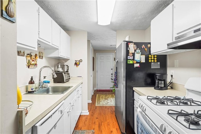 3184 Newcastle Way, Snellville, GA 30039 - kitchen with white appliances, a sink, a textured ceiling, light countertops, and light wood-style floors