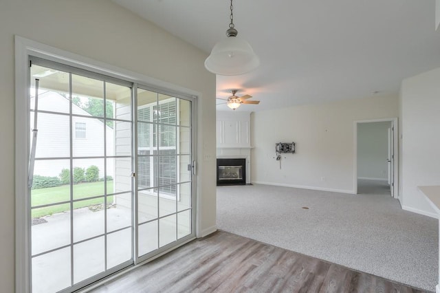 502 Helene Ct, Woodstock, GA 30188 - unfurnished living room featuring baseboards, a fireplace, a ceiling fan, light colored carpet, and light wood-style flooring