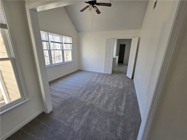 spare room with lofted ceiling, carpet floors, a ceiling fan, and baseboards